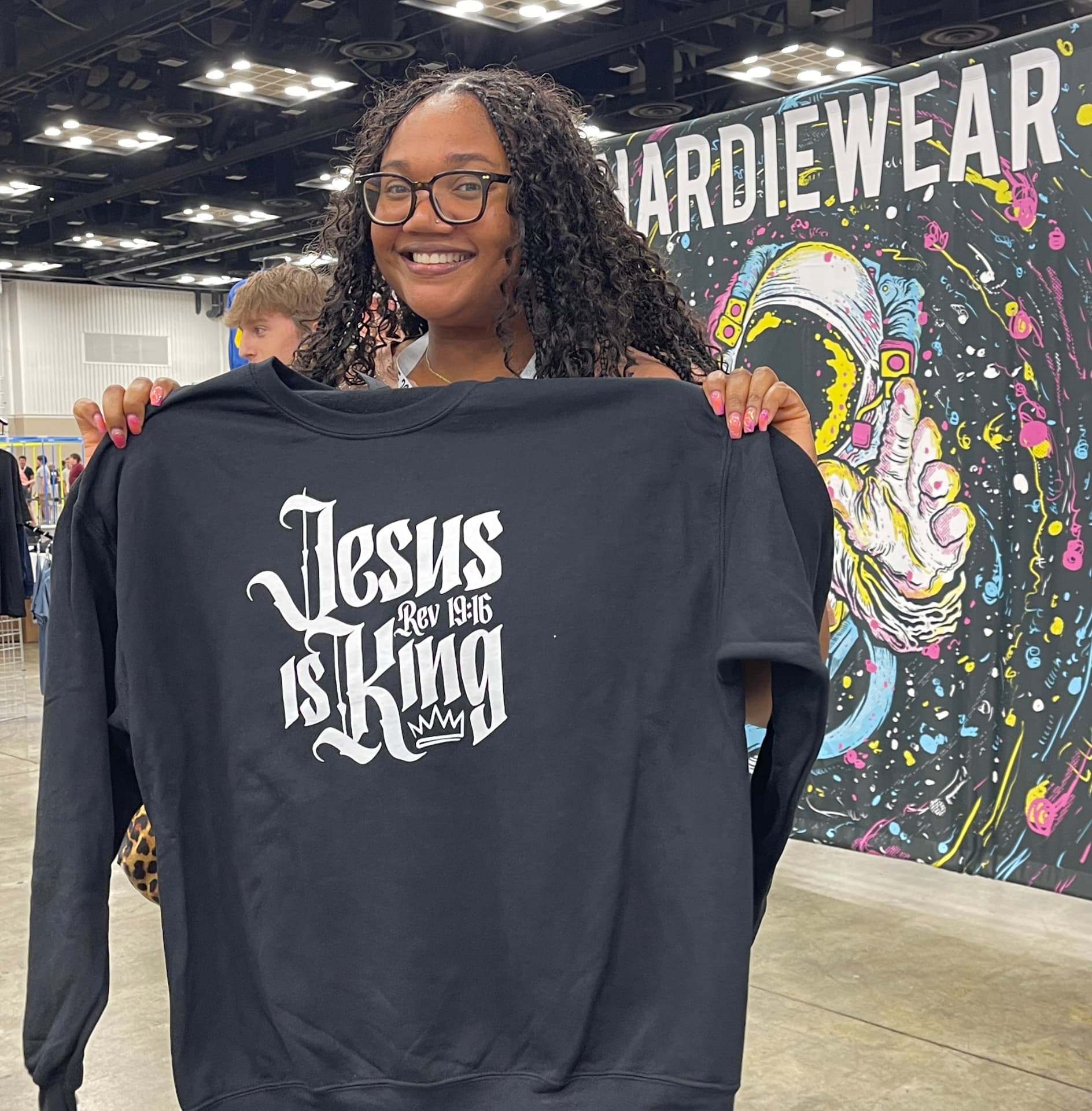 Custom printed faith-lettering crewneck sweatshirt held up by hand by Hardiewear