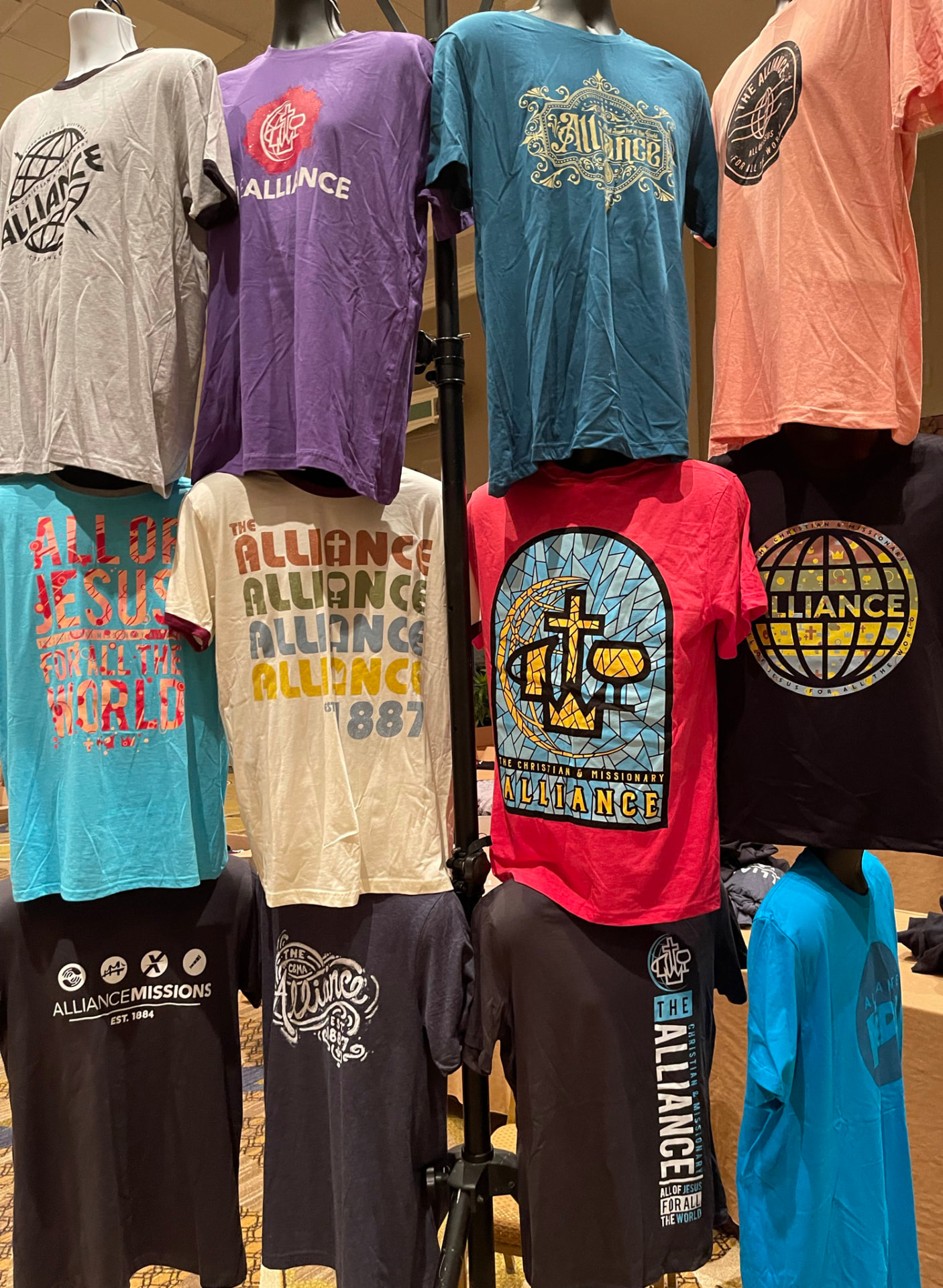 Custom printed graphic tees hanging on a retail rack by Hardiewear