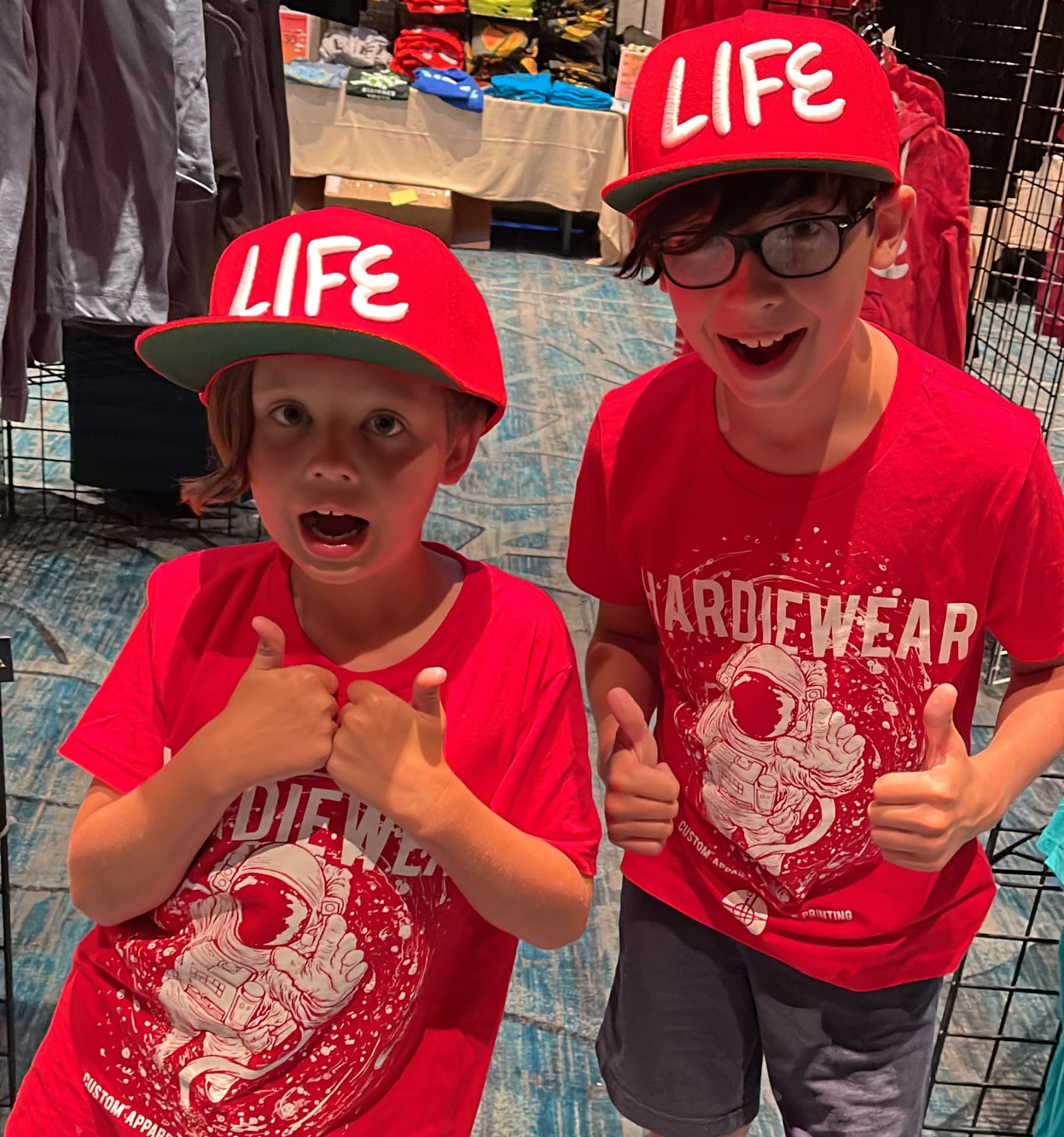 Two kids in red custom printed tees and snapback hats by Hardiewear