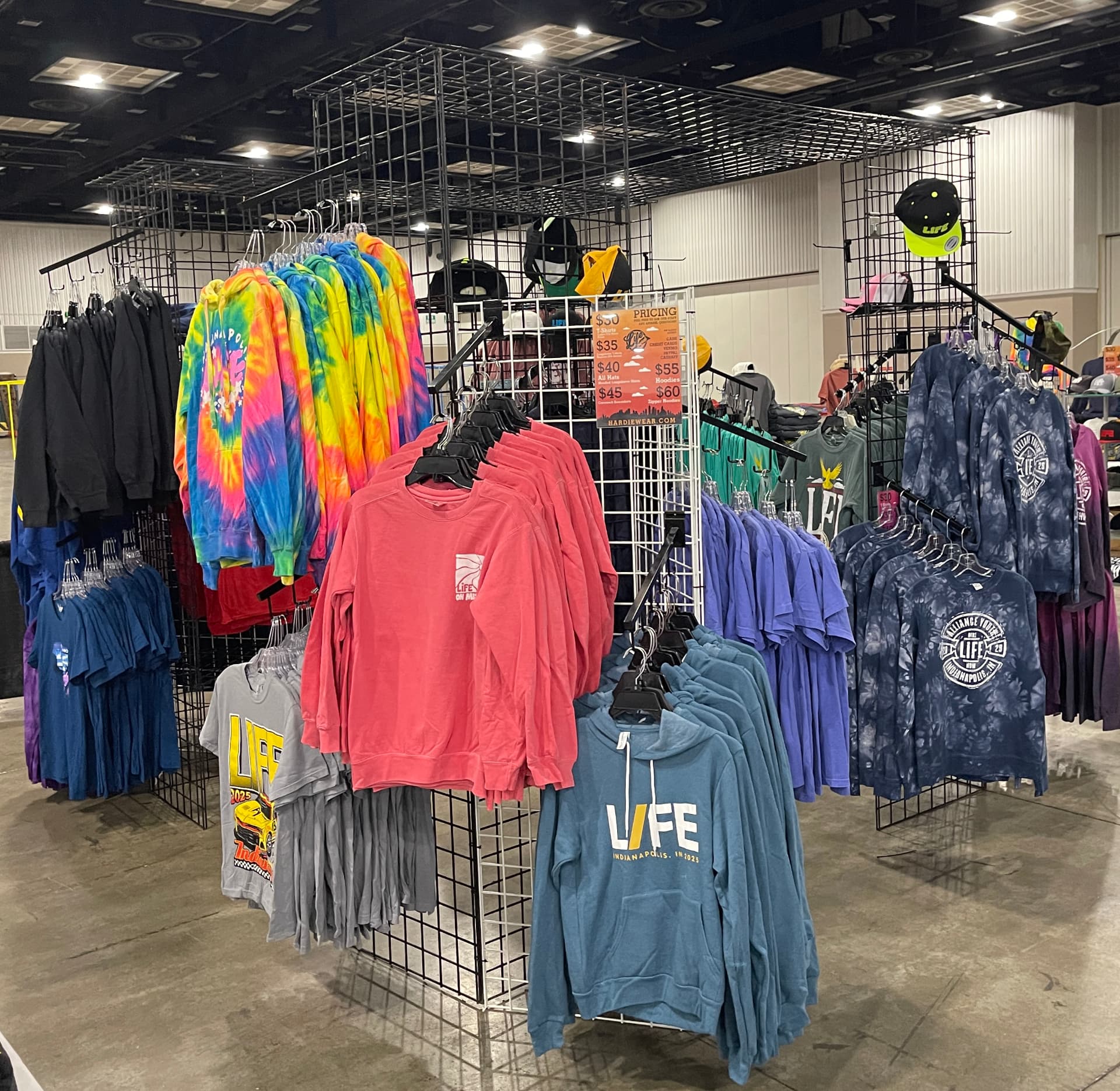 Custom tie-dye tees and hoodies on hanging retail racks by Hardiewear