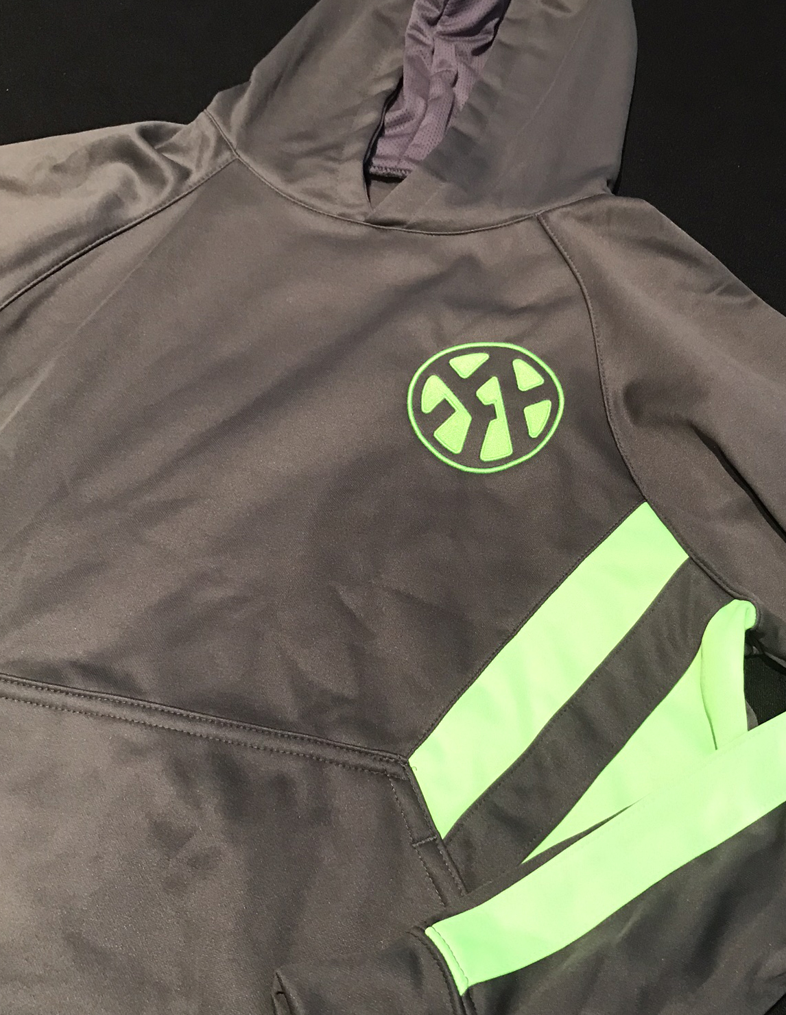 Charcoal performance hoodie with a custom green logo print by Hardiewear